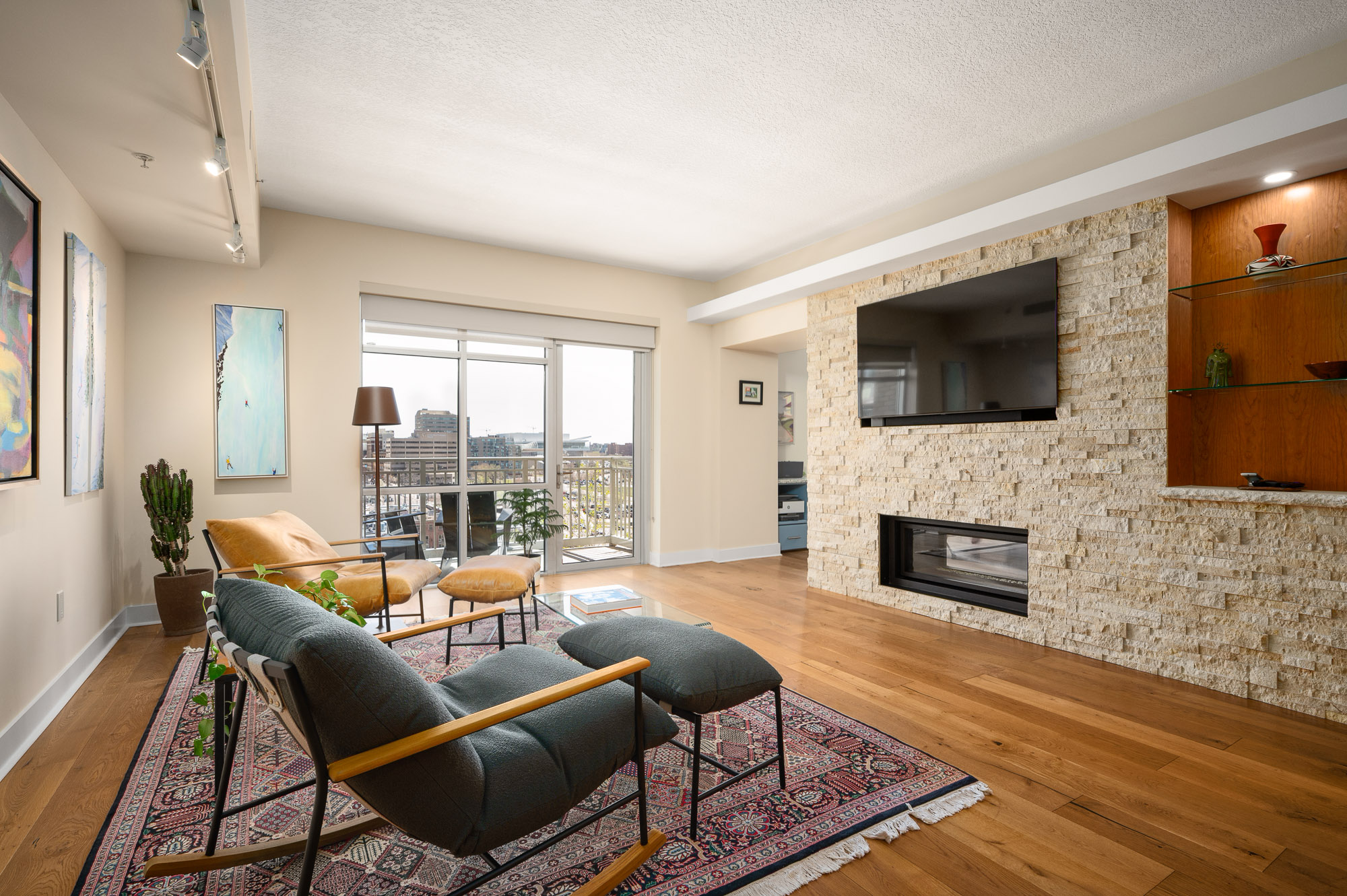 Contemporary Denver living room with stone fireplace, built-ins, and private balcony access