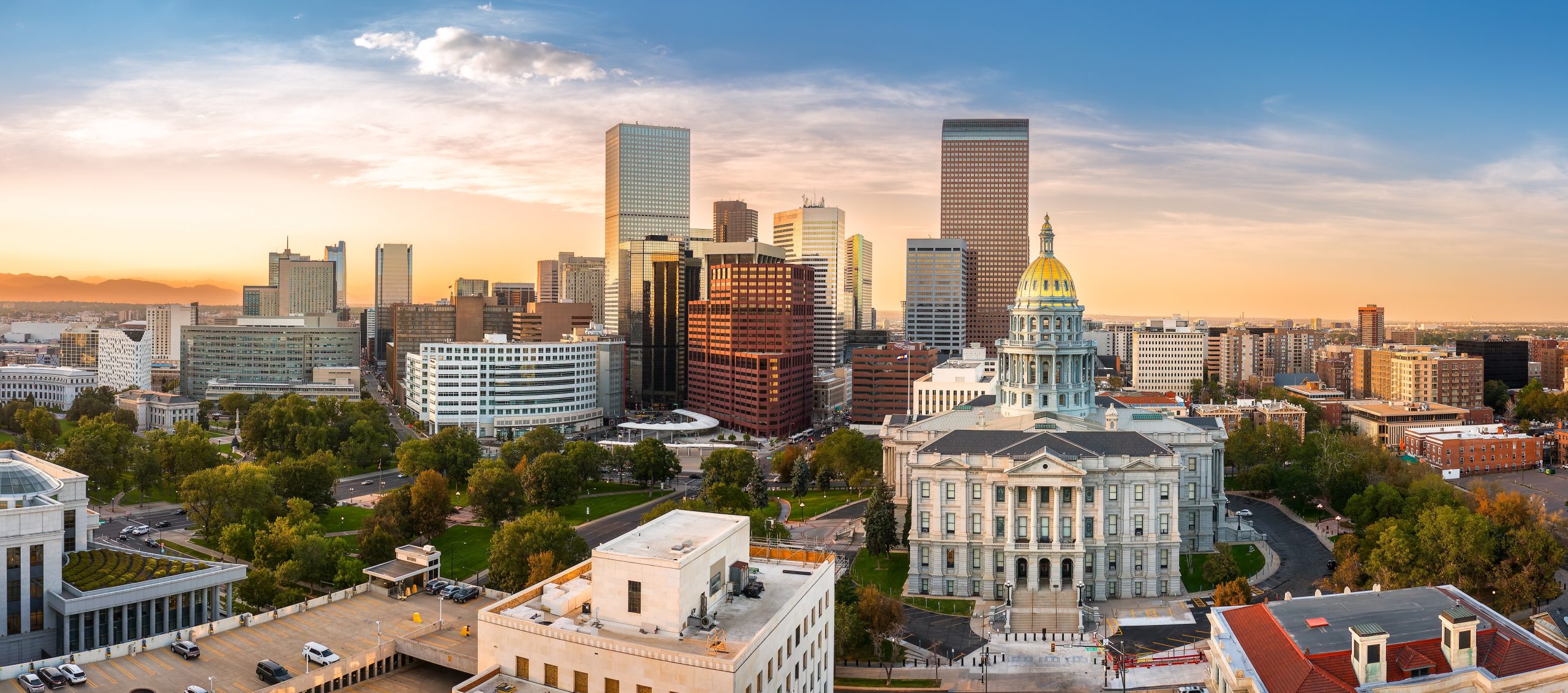 Downtown Denver skyline at sunset with Colorado State Capitol building in the foreground showcasing the vibrant cityscape and urban living opportunities.