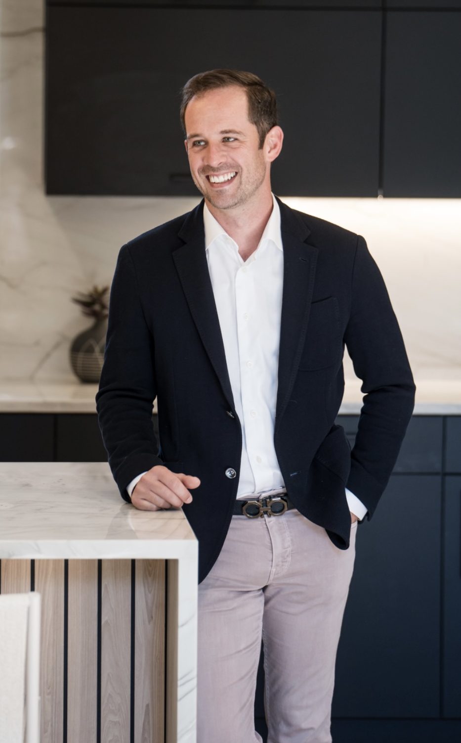 Nick Bruce, Denver real estate advisor, standing in a modern luxury kitchen with a confident and approachable demeanor.